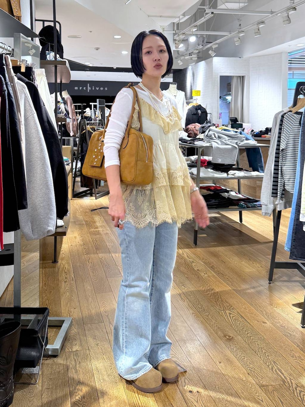 ホワイト系のTシャツ/カットソー、ブラウン系のボストンバッグ、ベージュ系のモカシン/デッキシューズを着用したレディースの春コーディネートの3枚目の写真