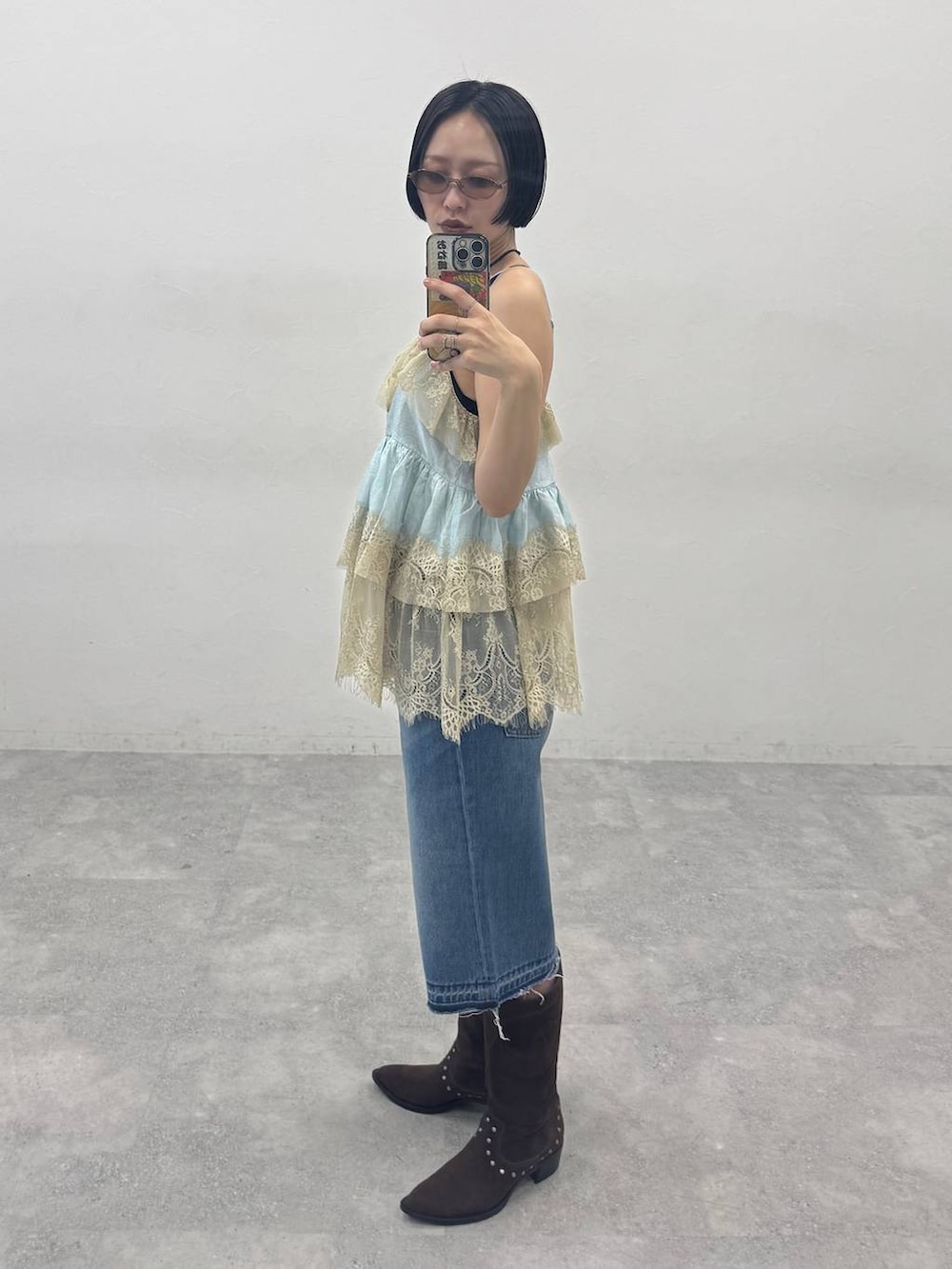 ブラウン系のブーツ、ブルー系のデニムパンツを着用したレディースの春コーディネートの3枚目の写真