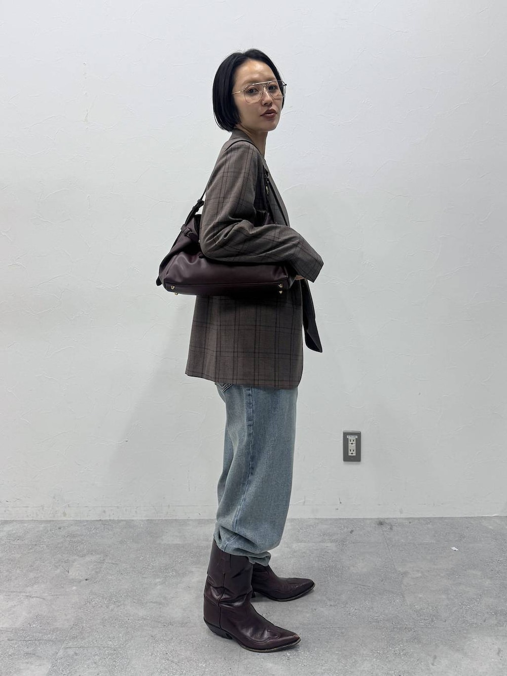 ブルー系のデニムパンツ、ブラウン系のTシャツ/カットソー、レッド系のショルダーバッグを着用したレディースの夏コーディネートの3枚目の写真