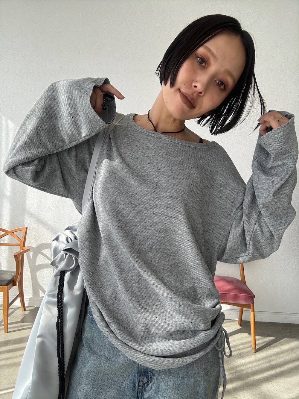 ブルー系のデニムパンツ、ブラック系のブーツ、グレー系のTシャツ/カットソーを着用したレディースの秋コーディネートの2枚目の写真