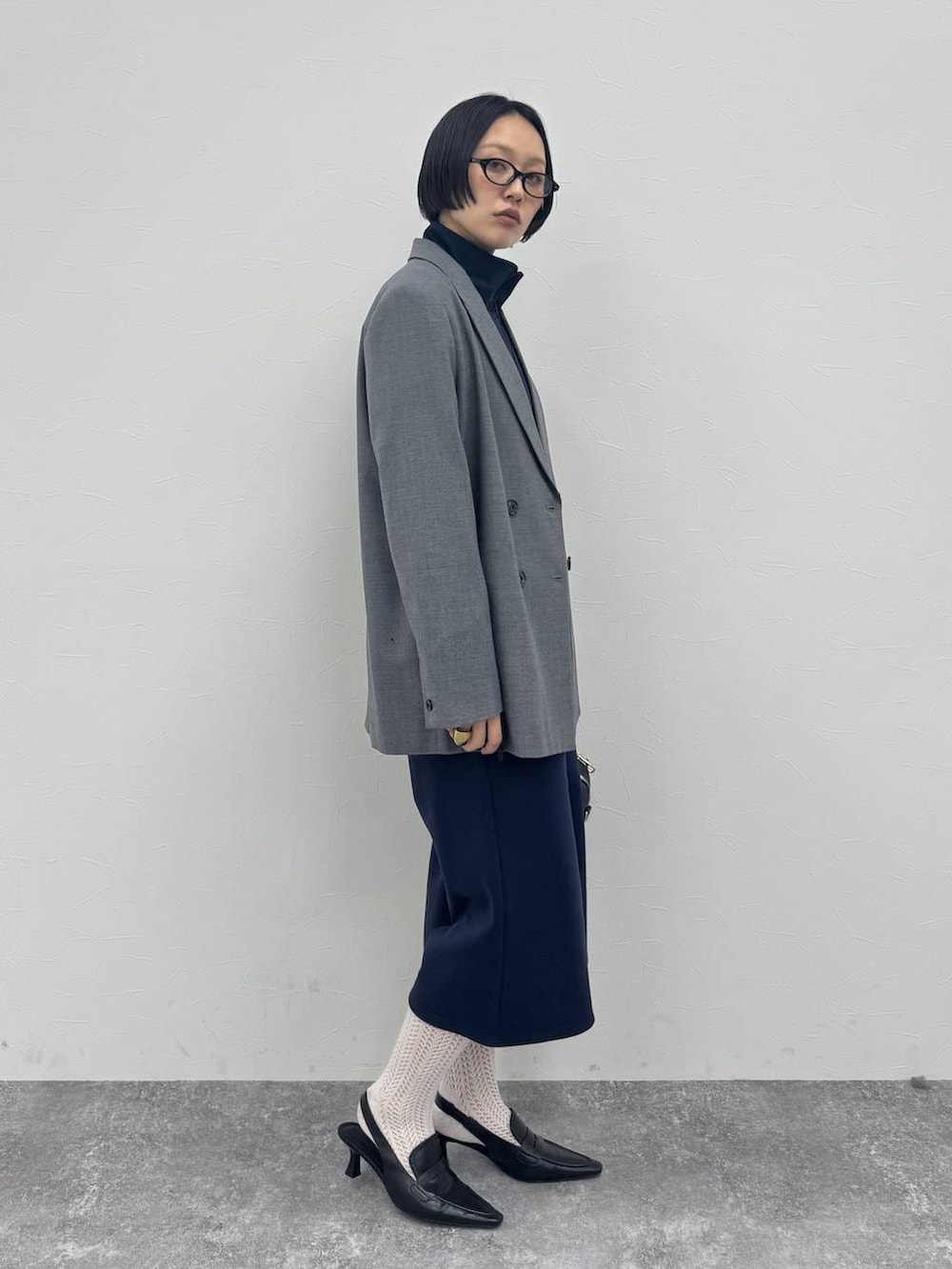 ブラック系のローファー、ブラック系のショルダーバッグ、グレー系のテーラードジャケットを着用したレディースの冬コーディネートの5枚目の写真