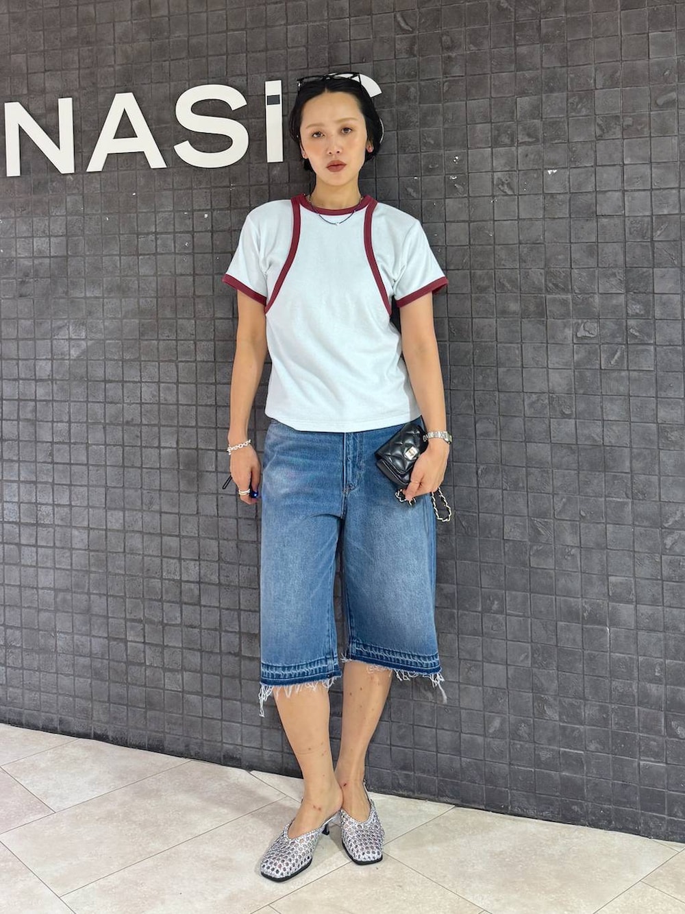 ブルー系のデニムパンツ、シルバー系のパンプスを着用したレディースの夏コーディネートの5枚目の写真