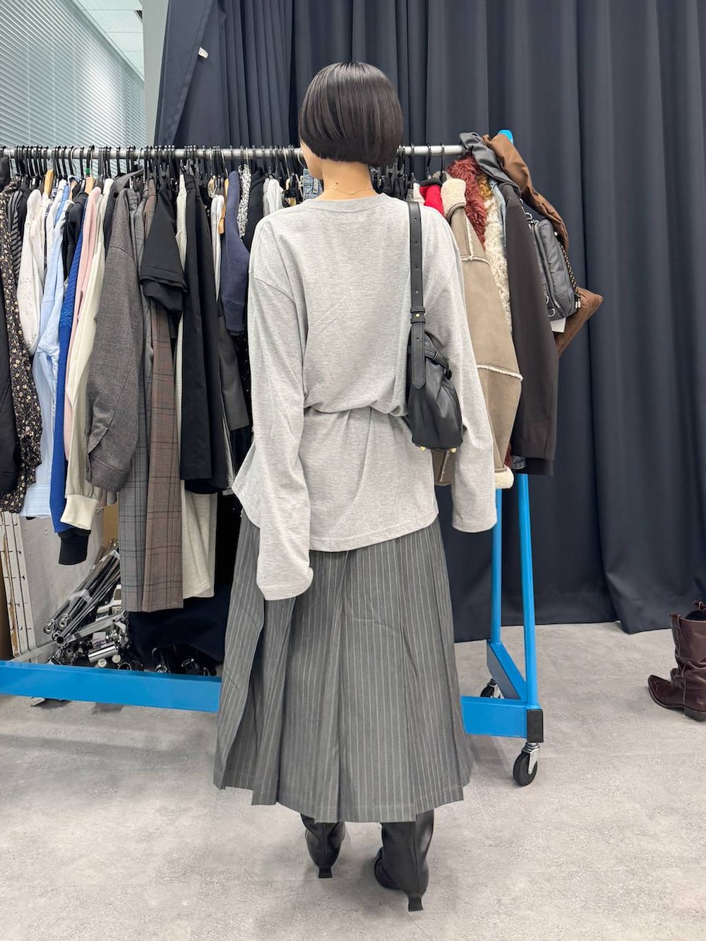 ブラック系のブーツ、ブラック系のショルダーバッグ、ホワイト系のTシャツ/カットソーを着用したレディースの夏コーディネートの4枚目の写真