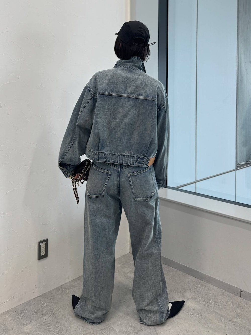 ブルー系のデニムジャケット、ブルー系のデニムパンツ、ブラック系のサンダルを着用したレディースの夏コーディネートの3枚目の写真