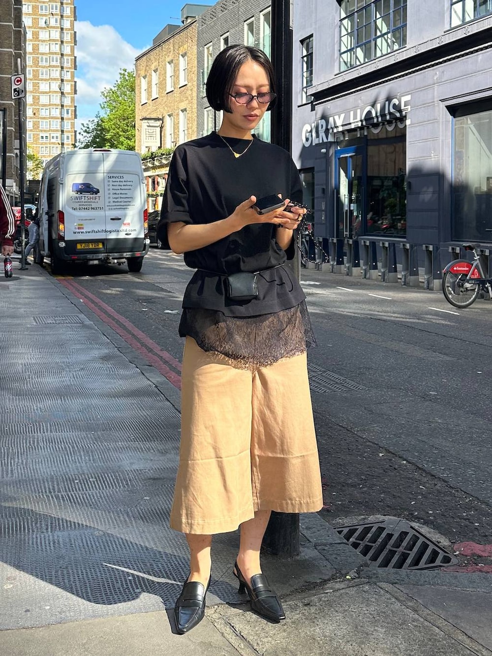 ブラック系のTシャツ/カットソー、ブラック系のベルト、ブラック系のサングラスを着用したレディースの夏コーディネートの2枚目の写真