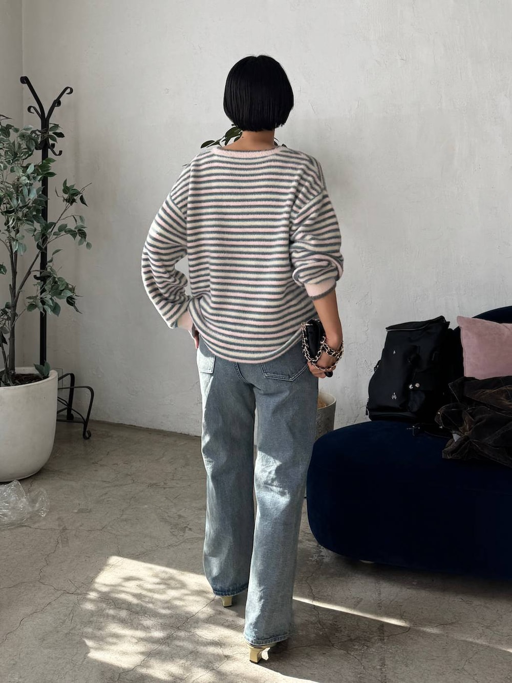 ブルー系のデニムパンツを着用したレディースの秋コーディネートの2枚目の写真