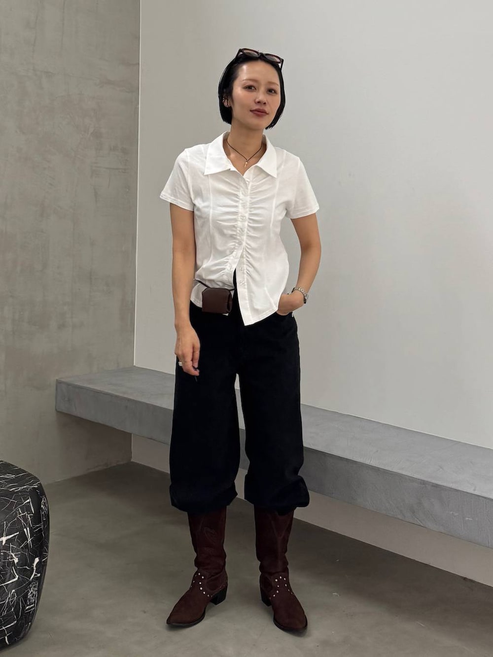 ブラウン系のブーツ、ブラック系のデニムパンツ、ホワイト系のシャツ/ブラウスを着用したレディースの春コーディネートの2枚目の写真