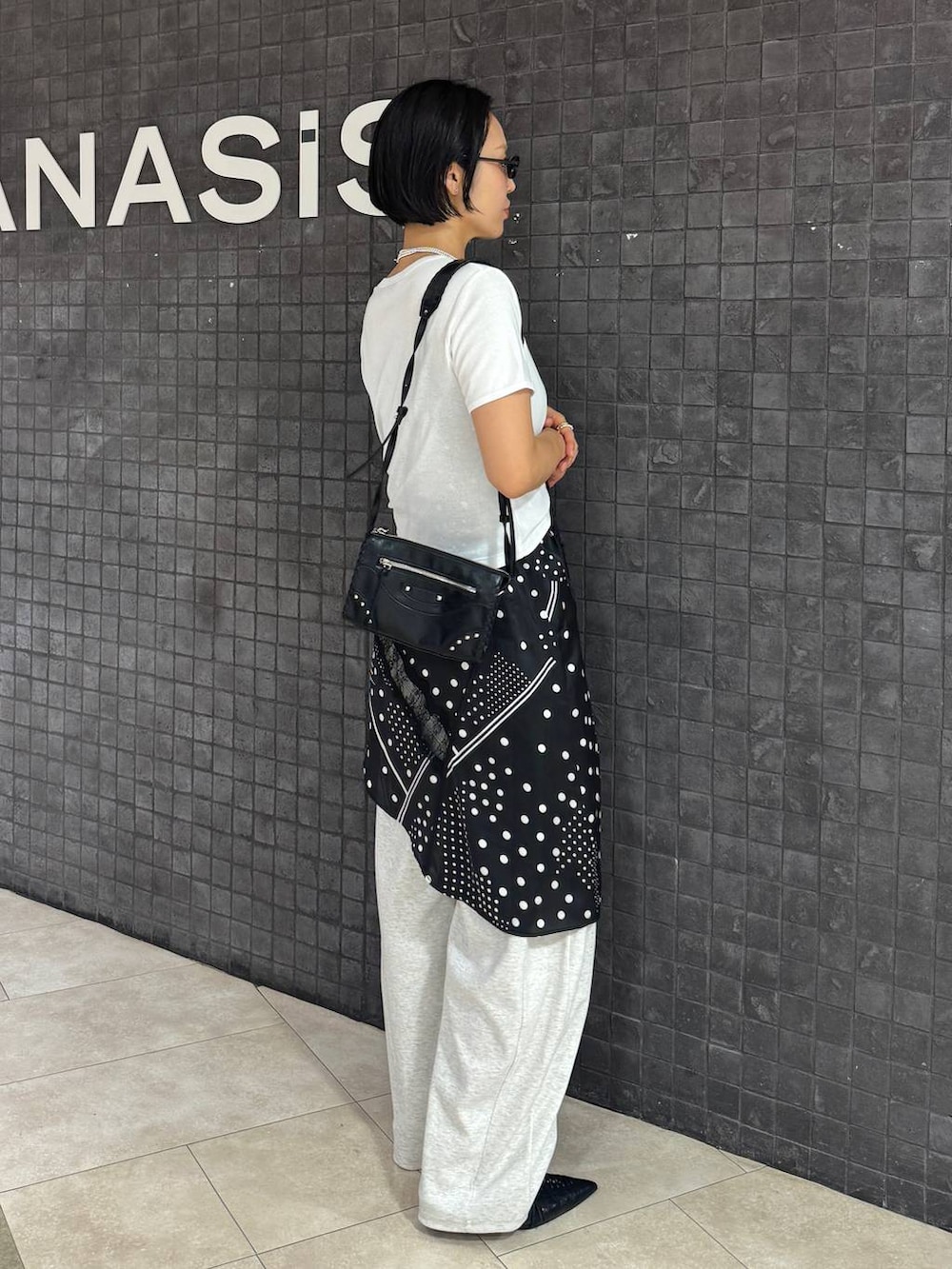 ブラック系のチュニック、ブラック系のパンプス、ホワイト系のTシャツ/カットソーを着用したレディースの夏コーディネートの5枚目の写真