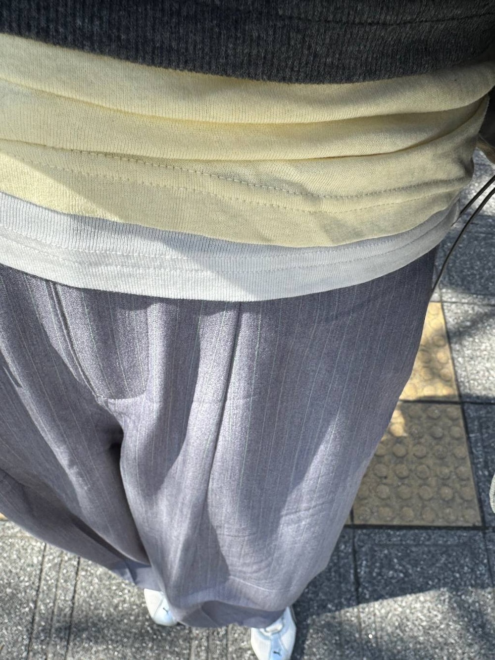 ホワイト系のTシャツ/カットソー、グレー系のタンクトップ、グレー系のスラックスを着用したレディースの春コーディネートの2枚目の写真