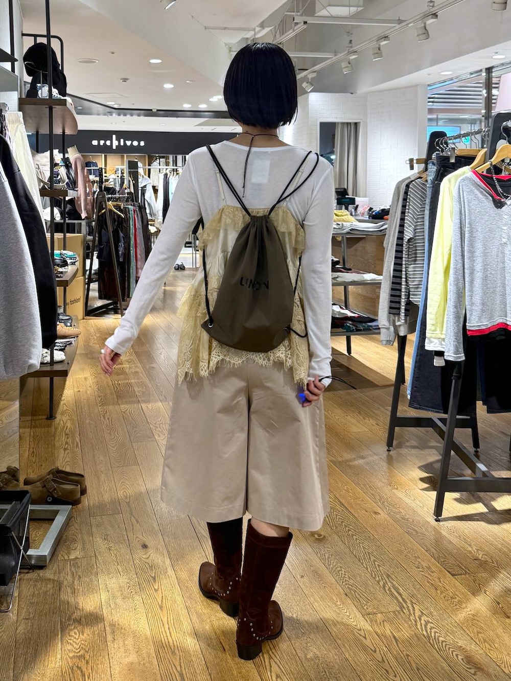 ホワイト系のTシャツ/カットソー、ブラウン系のブーツ、ベージュ系のその他パンツを着用したレディースの春コーディネートの4枚目の写真