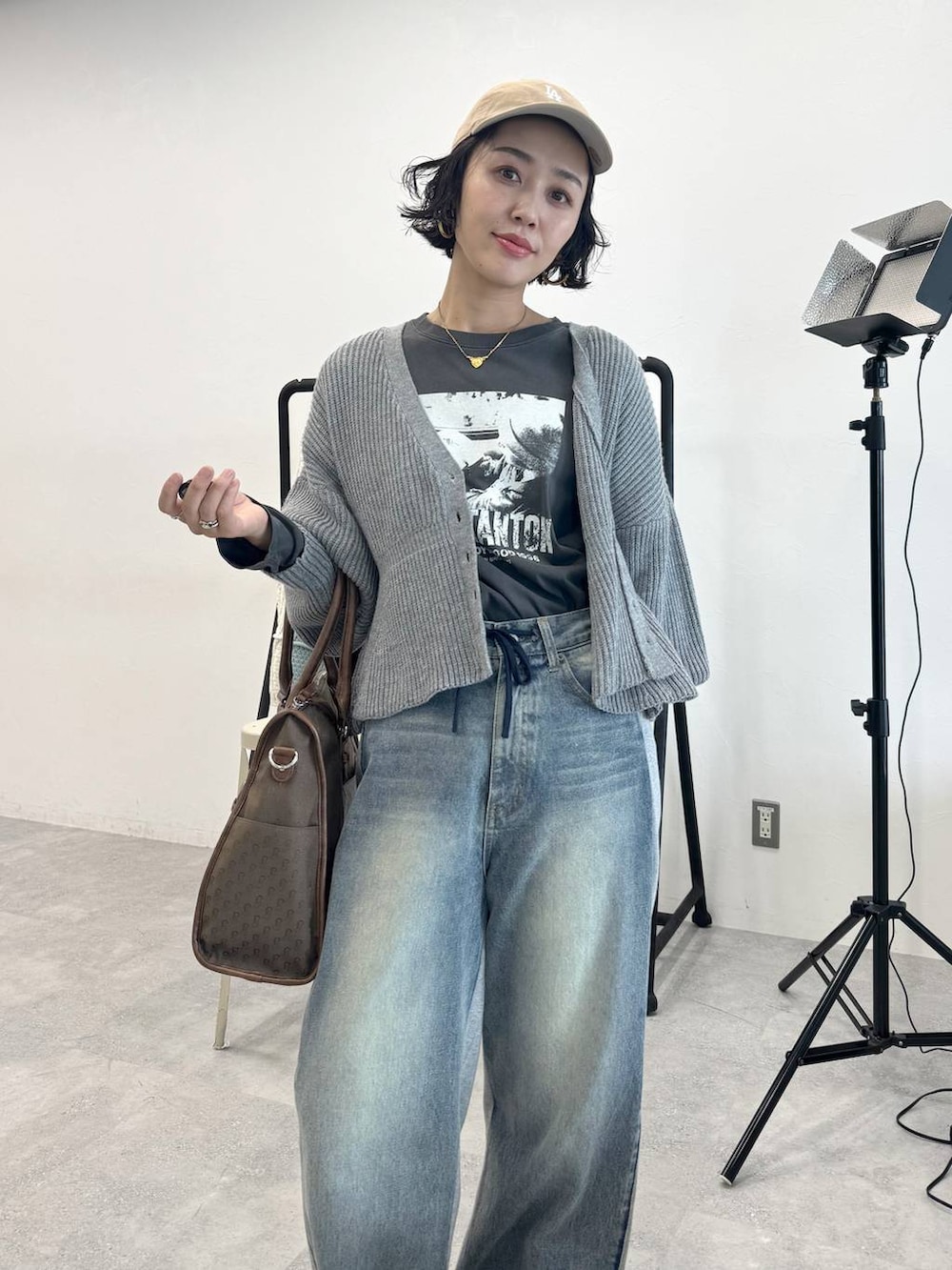 ブルー系のデニムパンツ、グリーン系のトートバッグ、グレー系のTシャツ/カットソーを着用したレディースの秋コーディネートの7枚目の写真