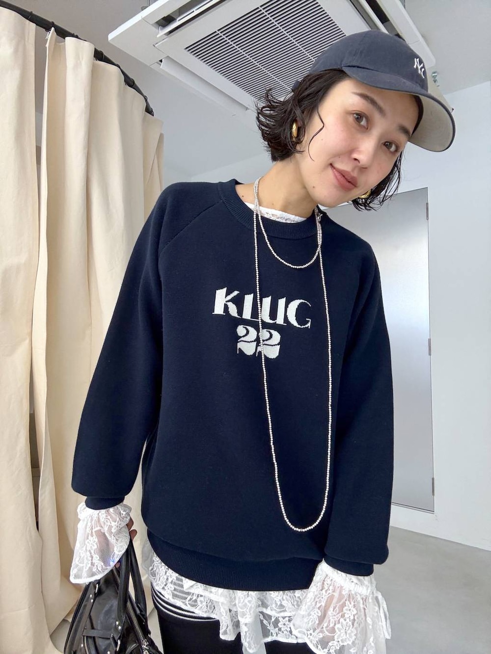 ブラック系のボストンバッグ、ホワイト系のシャツ/ブラウスを着用したレディースの秋コーディネートの3枚目の写真