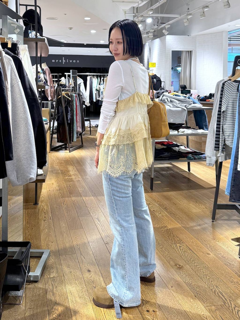 ホワイト系のTシャツ/カットソー、ブラウン系のボストンバッグ、ベージュ系のモカシン/デッキシューズを着用したレディースの春コーディネートの6枚目の写真