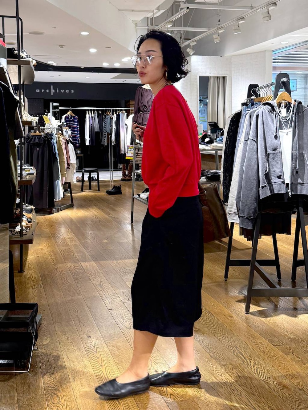 グリーン系のトートバッグ、ブラック系のその他パンツ、レッド系のスウェットを着用したレディースの秋コーディネートの2枚目の写真