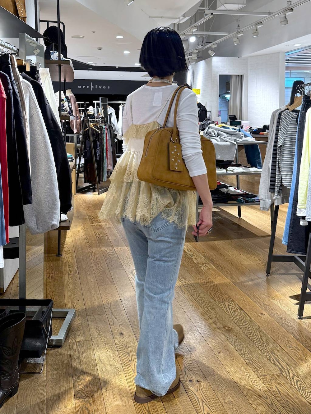 ホワイト系のTシャツ/カットソー、ブラウン系のボストンバッグ、ベージュ系のモカシン/デッキシューズを着用したレディースの春コーディネートの4枚目の写真