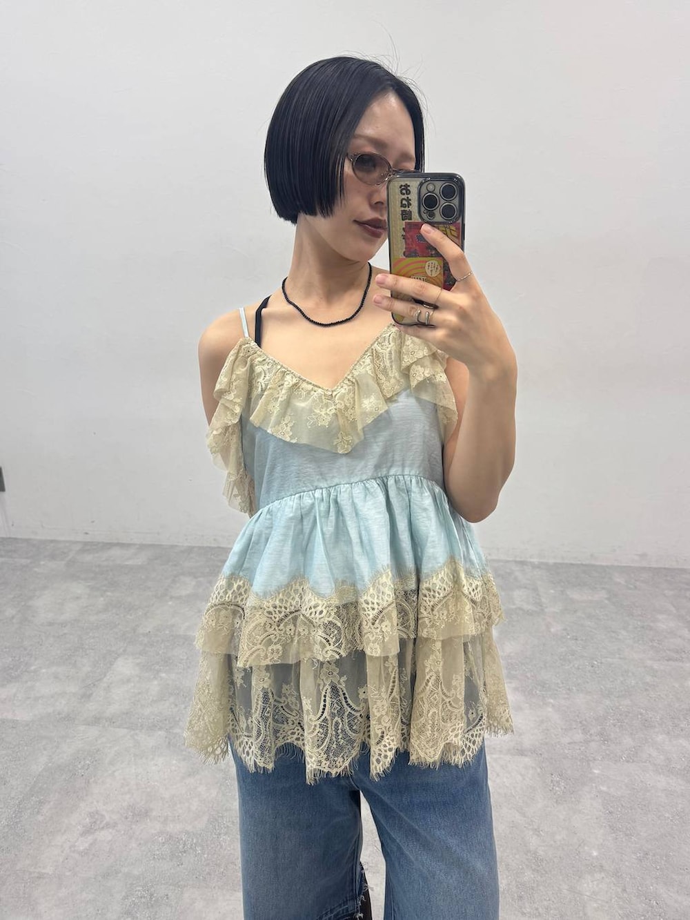 ブラウン系のブーツ、ブルー系のデニムパンツを着用したレディースの春コーディネートの2枚目の写真