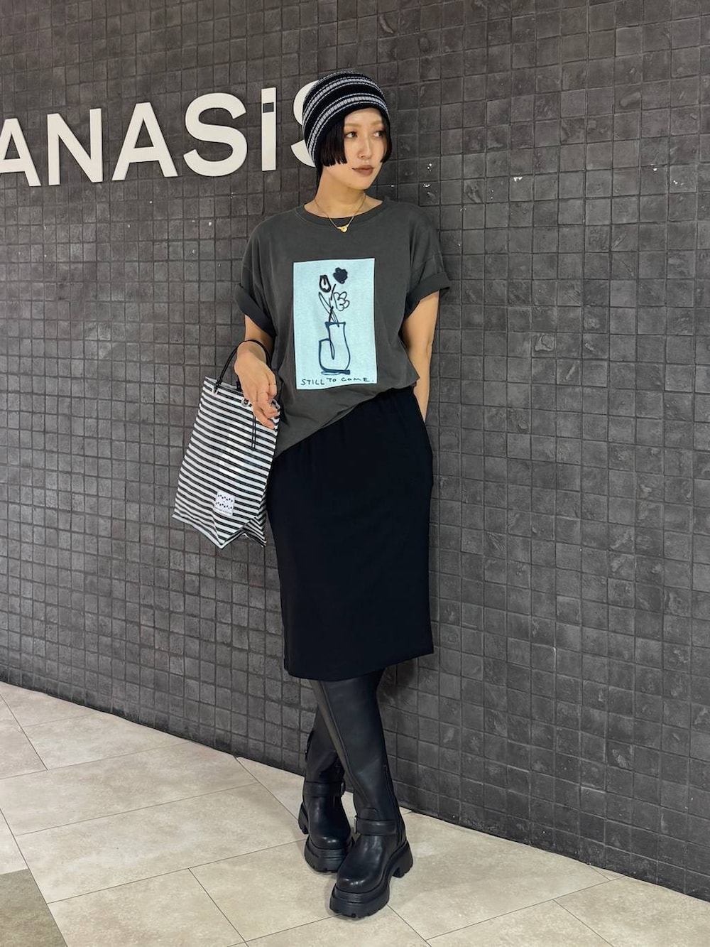 ブラック系のスカート、グレー系のTシャツ/カットソー、ブラック系のブーツを着用したレディースの夏コーディネートの5枚目の写真
