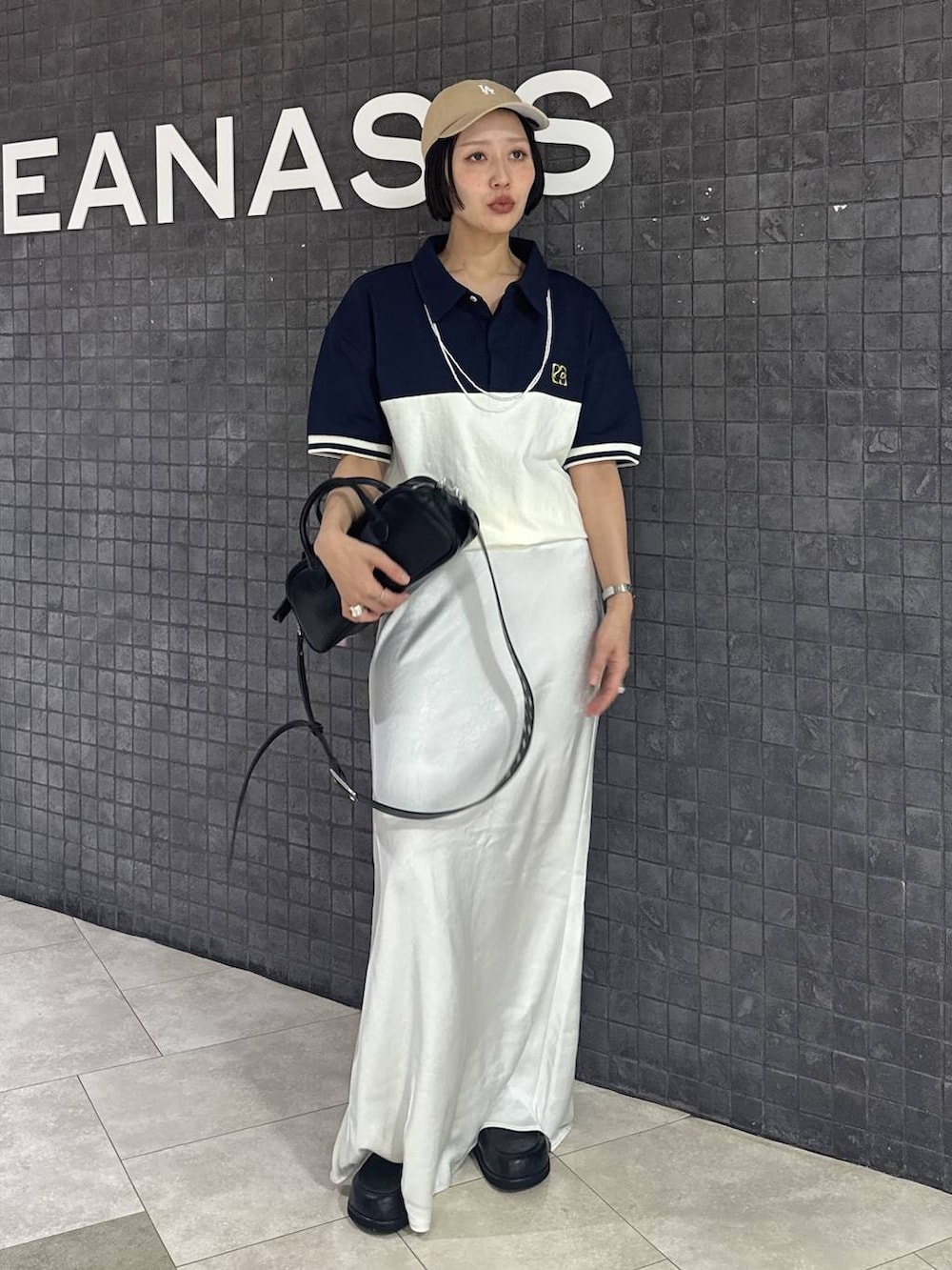 ブラック系のボストンバッグ、ブラック系のスカート、ブラック系のローファーを着用したレディースの春コーディネートの10枚目の写真