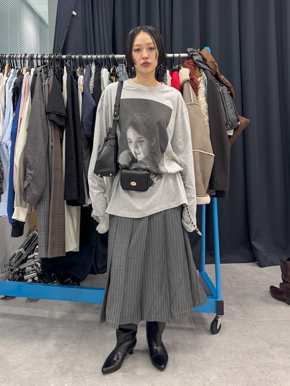 ブラック系のブーツ、ブラック系のショルダーバッグ、ホワイト系のTシャツ/カットソーを着用したレディースの夏コーディネートの3枚目の写真