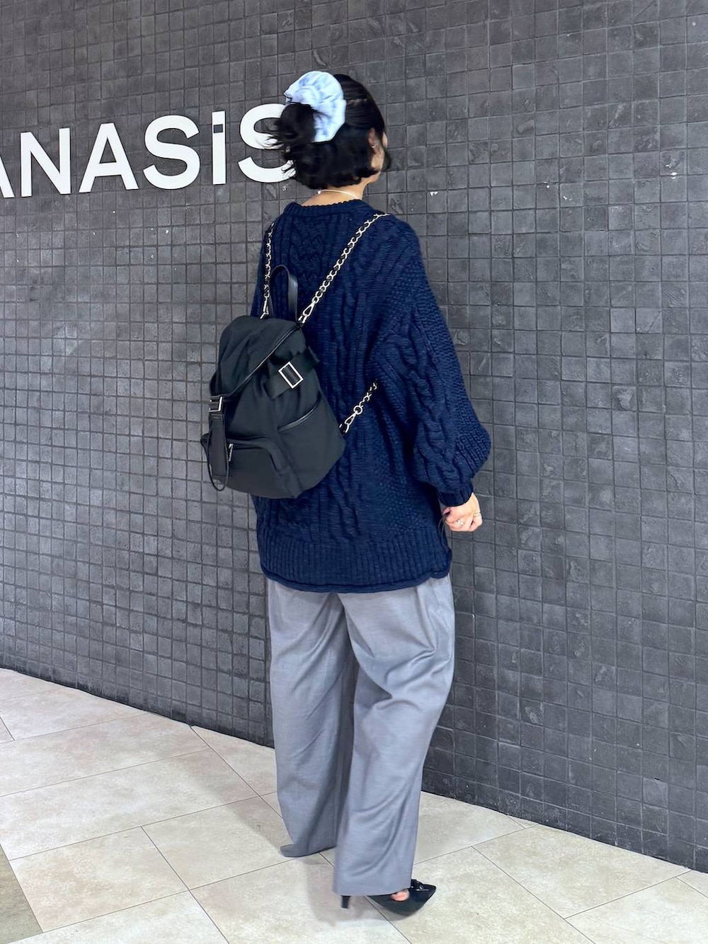 ブラック系のパンプス、グレー系のスラックスを着用したレディースの秋コーディネートの3枚目の写真