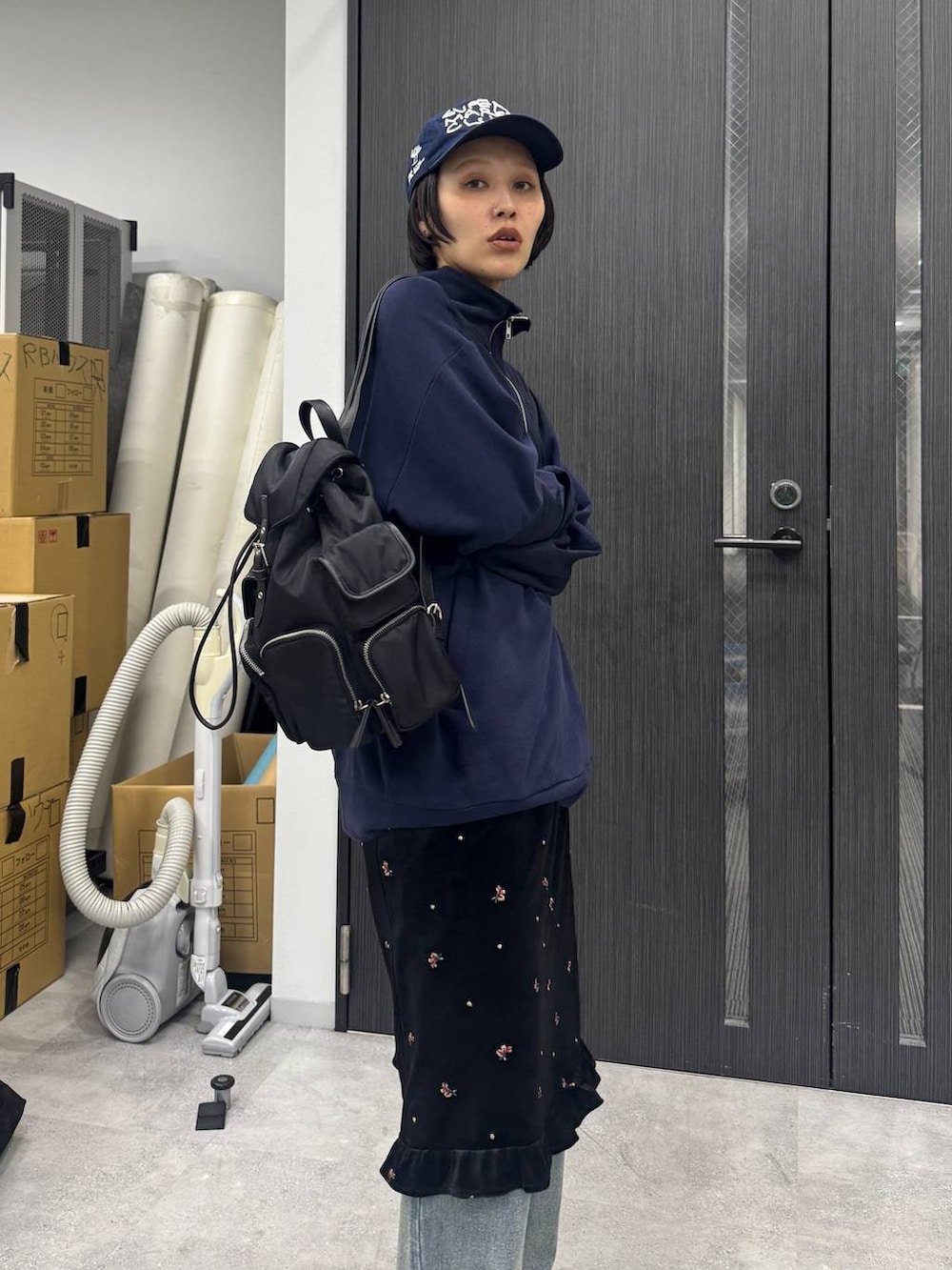 ブルー系のデニムパンツ、ブラック系のバックパック/リュック、ブルー系のスウェットを着用したレディースの夏コーディネートの4枚目の写真