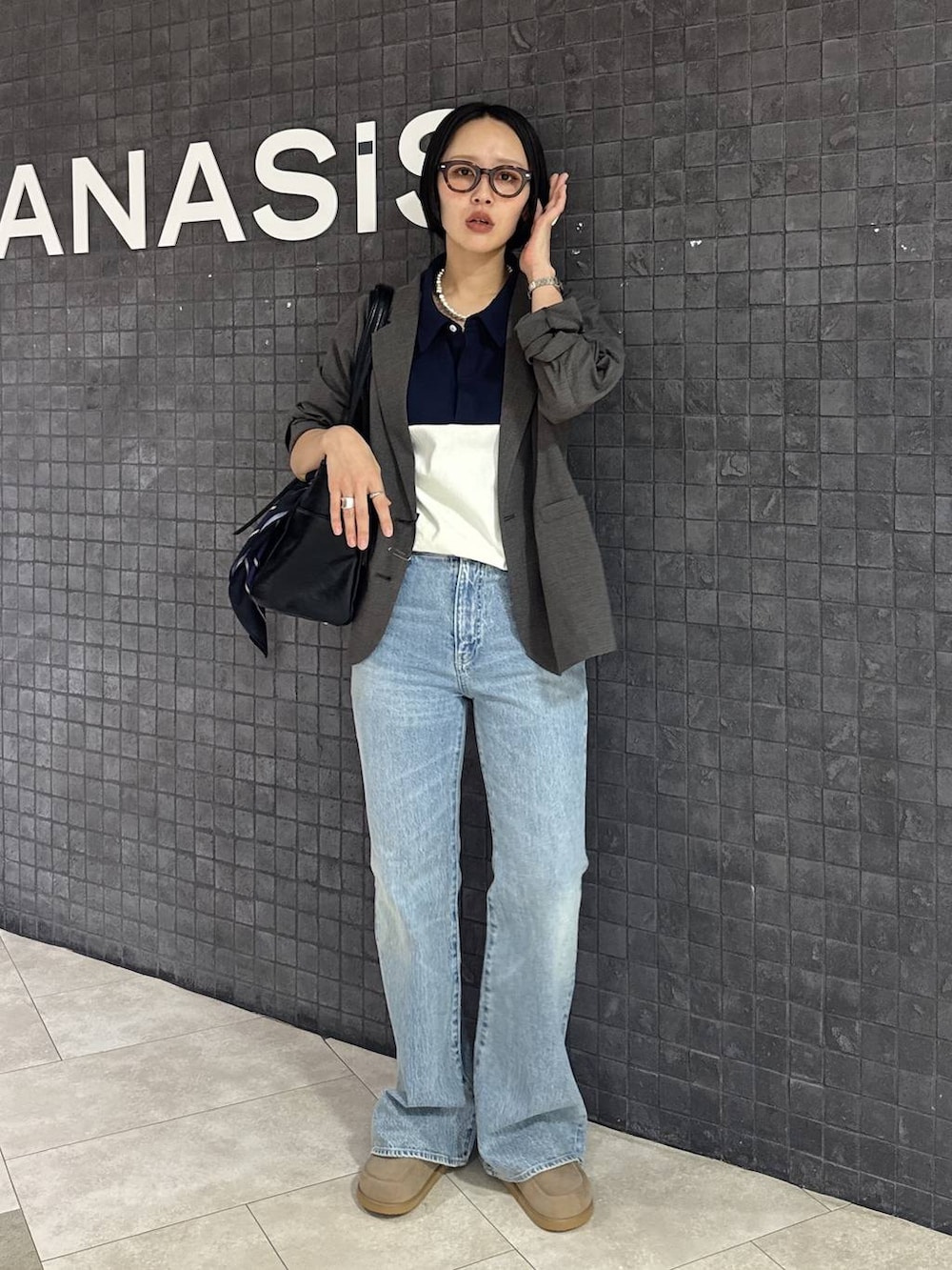 ブルー系のデニムパンツ、ベージュ系のローファー、ブラック系のトートバッグを着用したレディースの春コーディネートの8枚目の写真