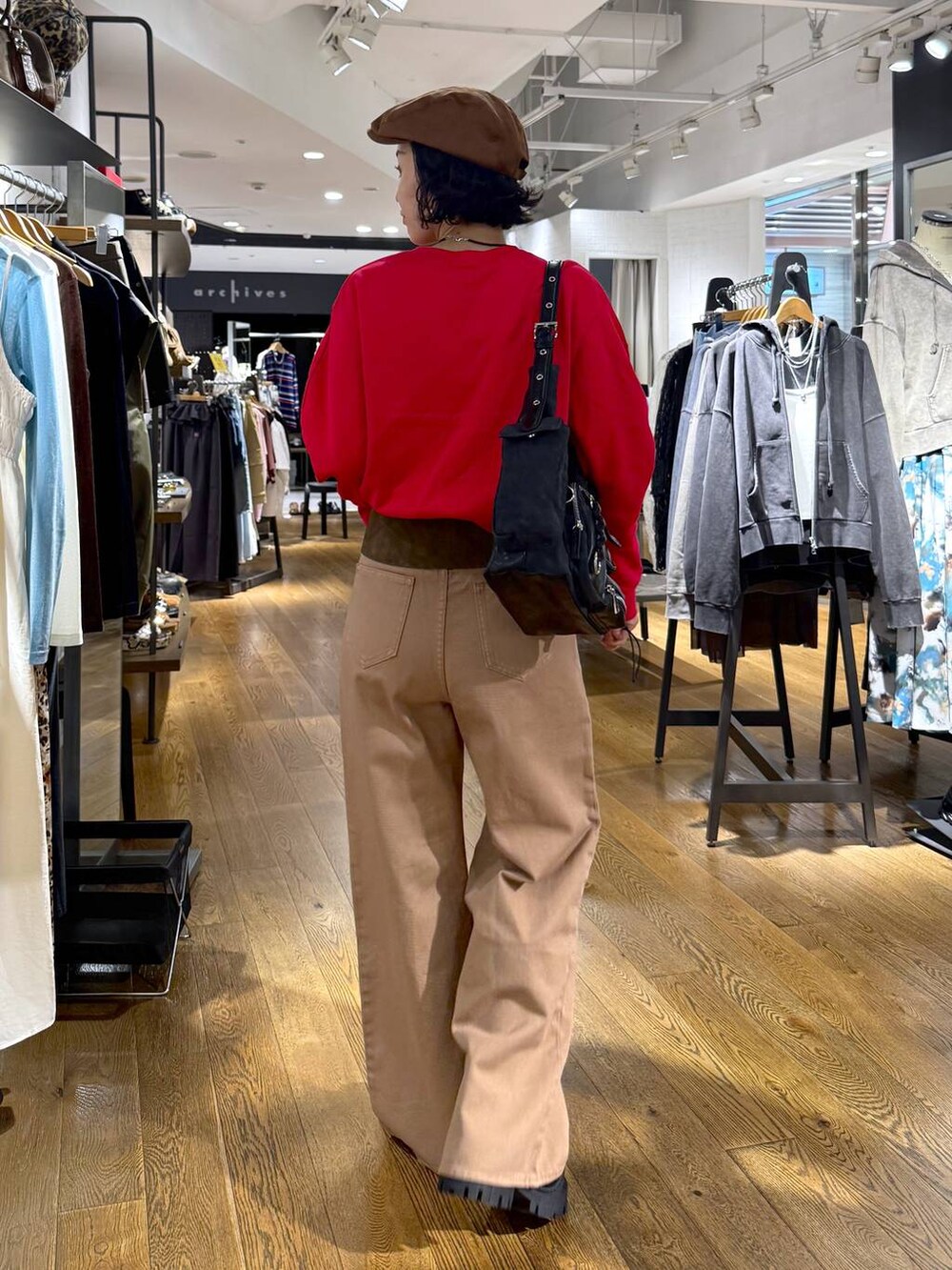 ベージュ系のデニムパンツ、ブラック系のショルダーバッグ、ブラック系のブーツを着用したレディースの秋コーディネートの6枚目の写真