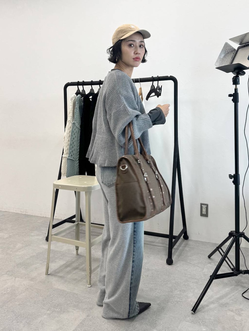 ブルー系のデニムパンツ、グリーン系のトートバッグ、グレー系のTシャツ/カットソーを着用したレディースの秋コーディネートの5枚目の写真