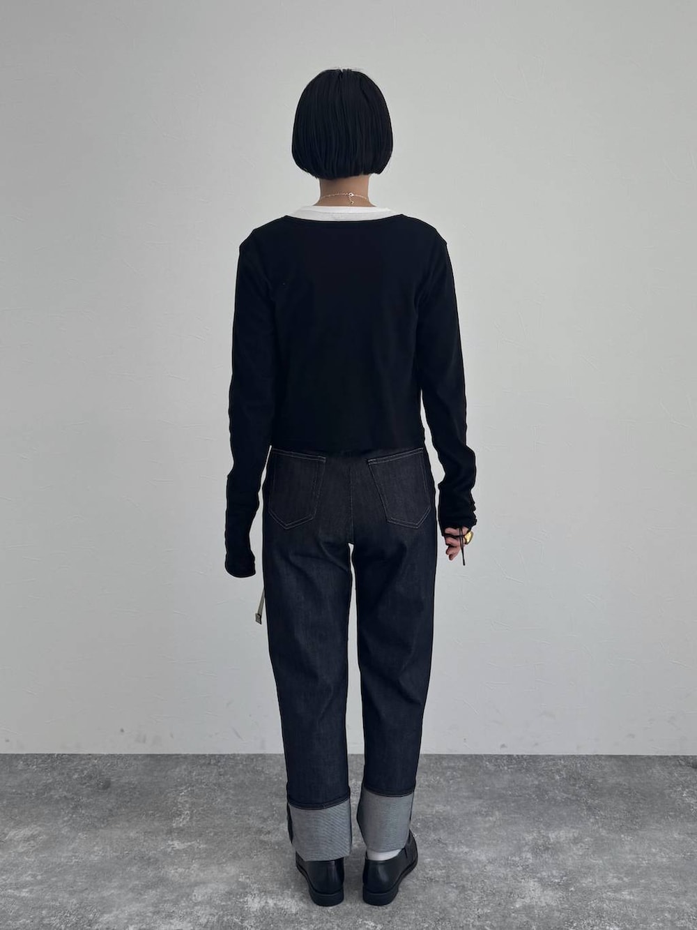 ブラック系のローファー、ブルー系のデニムパンツを着用したレディースの冬コーディネートの4枚目の写真