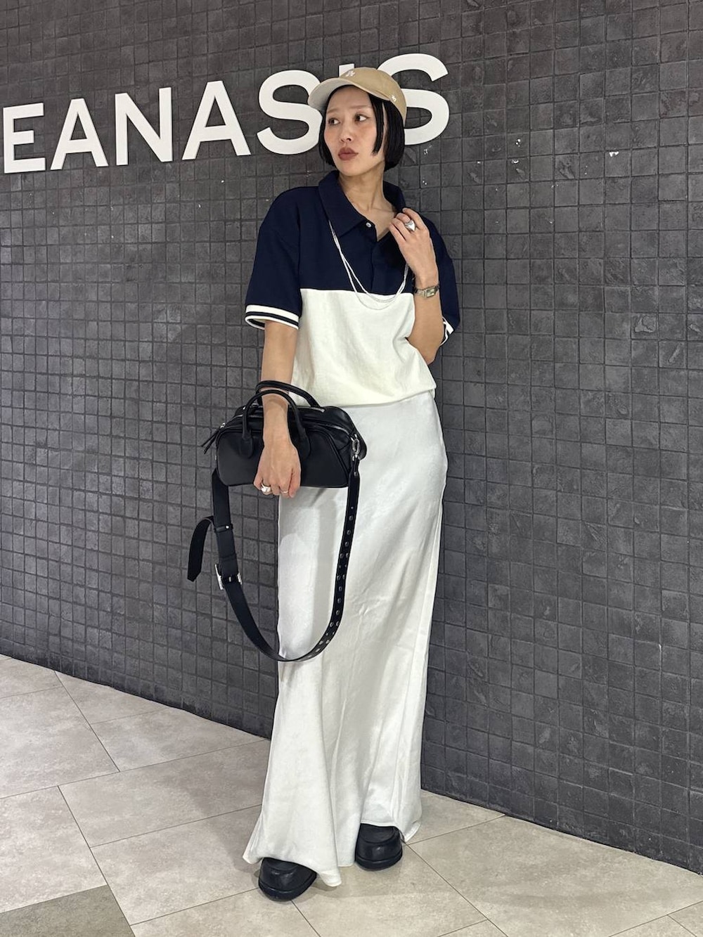 ブラック系のボストンバッグ、ブラック系のスカート、ブラック系のローファーを着用したレディースの春コーディネートの7枚目の写真