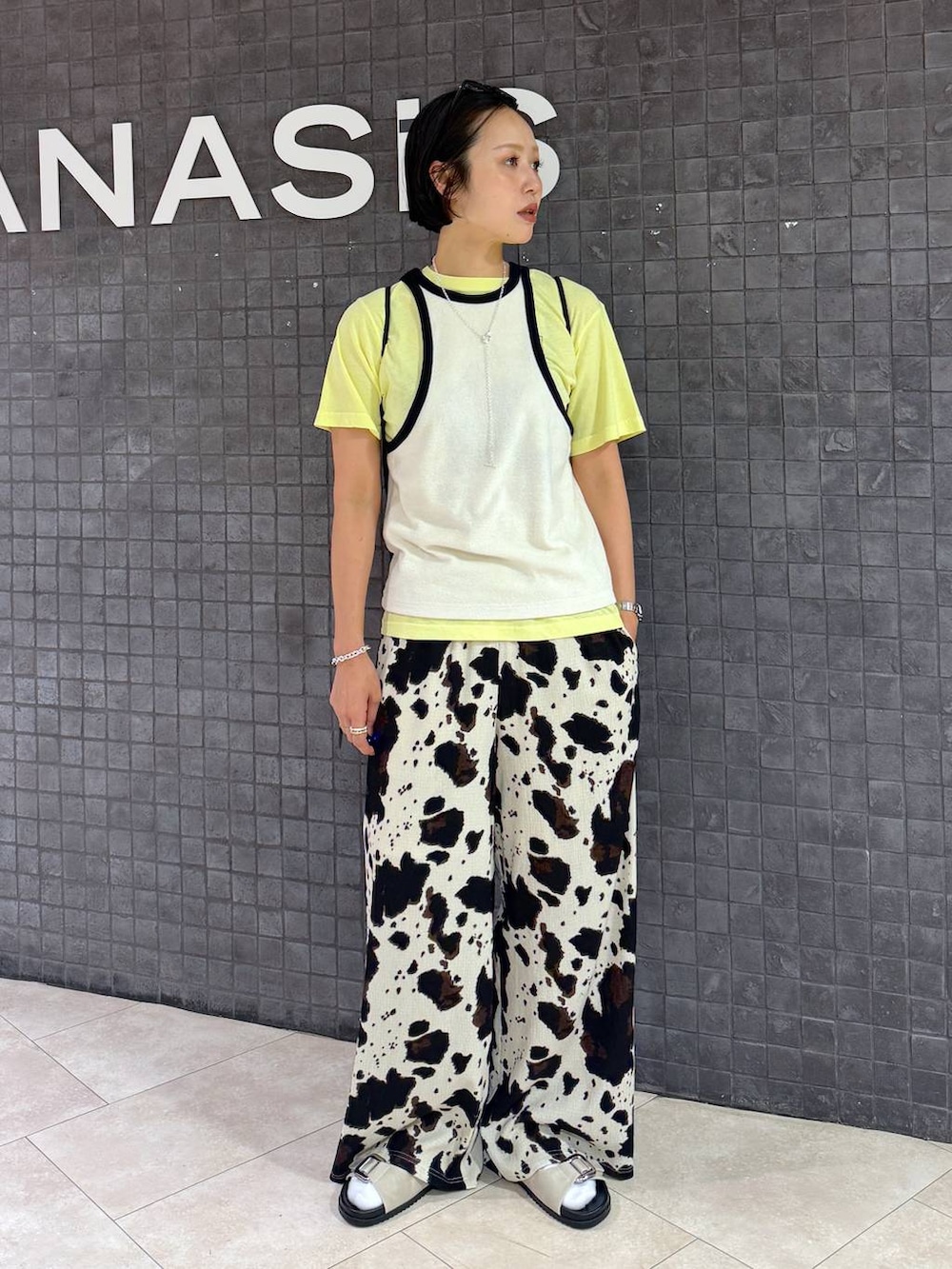 ベージュ系のその他パンツ、ホワイト系のサンダル、イエロー系のTシャツ/カットソーを着用したレディースの夏コーディネートの3枚目の写真