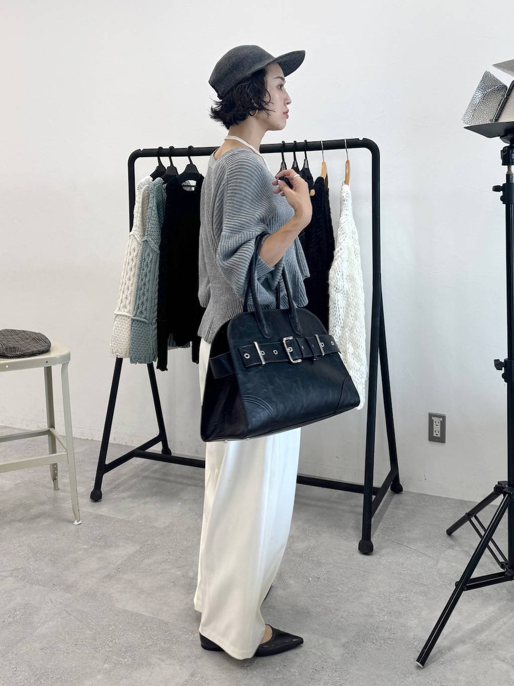 ホワイト系のスラックス、ブラック系のショルダーバッグ、グレー系のカーディガン/ボレロを着用したレディースの秋コーディネートの3枚目の写真