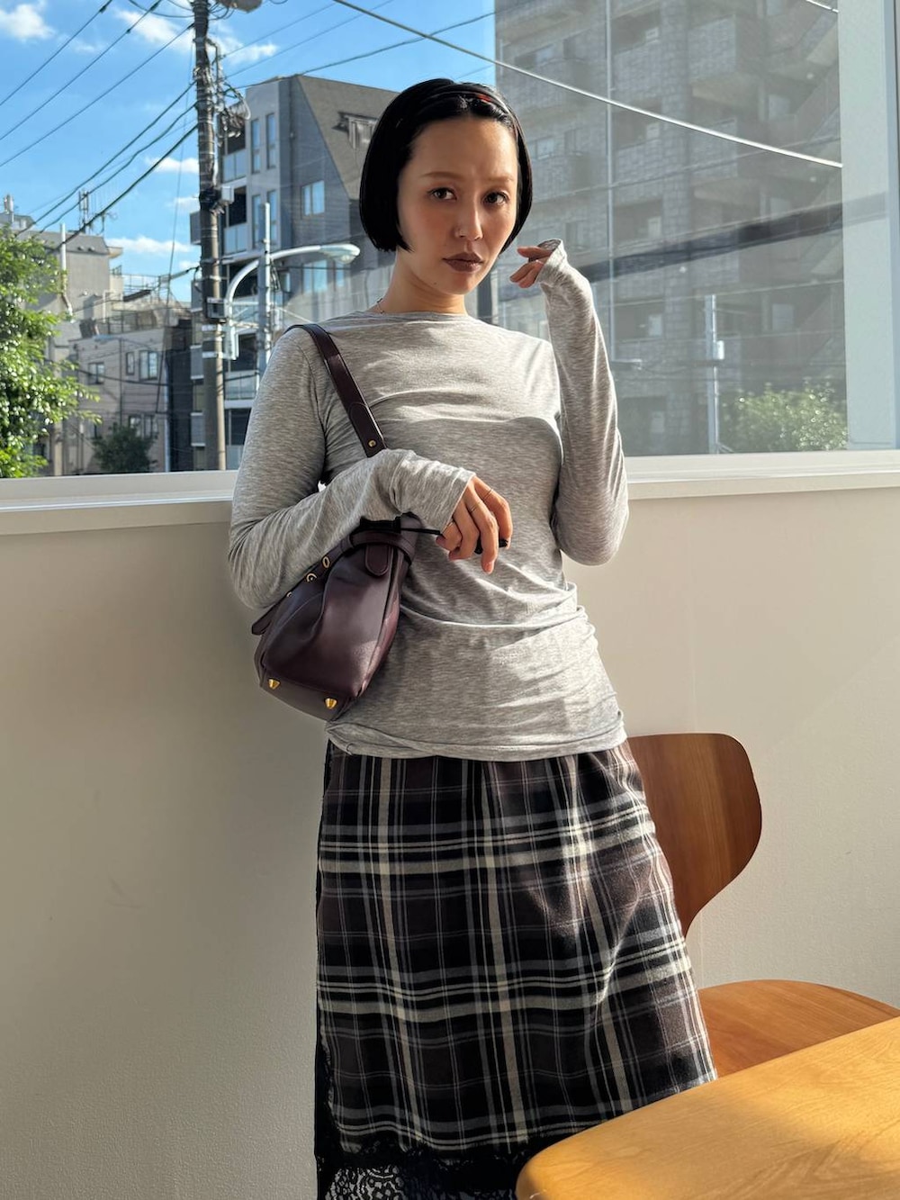 グレー系のTシャツ/カットソー、レッド系のショルダーバッグ、ブルー系のデニムパンツを着用したレディースの秋コーディネートの4枚目の写真
