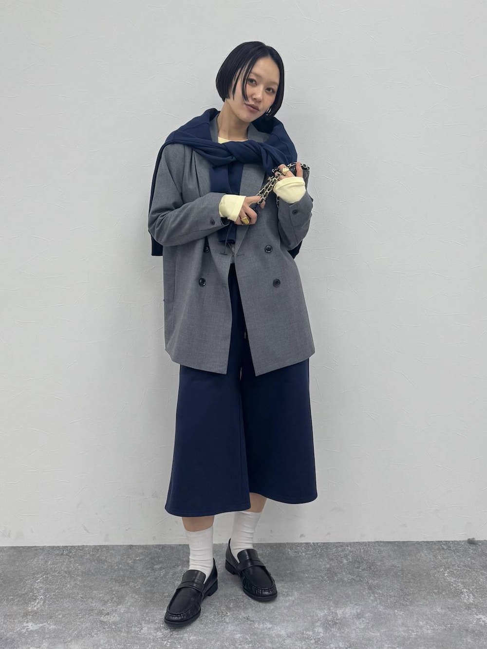 グレー系のテーラードジャケット、ブラック系のローファーを着用したレディースの冬コーディネートの6枚目の写真