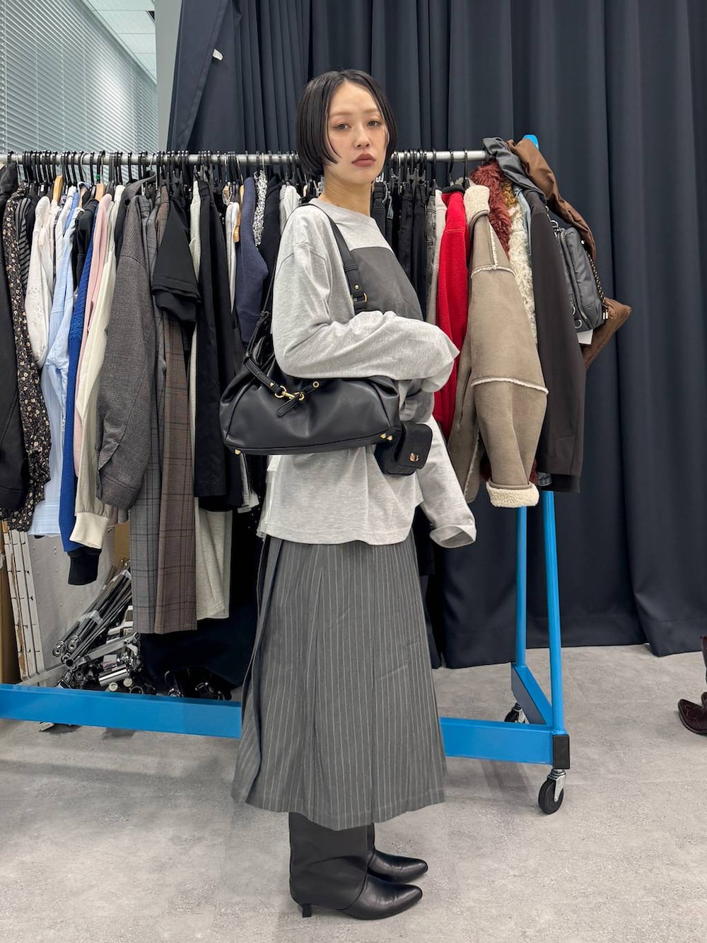 ブラック系のブーツ、ブラック系のショルダーバッグ、ホワイト系のTシャツ/カットソーを着用したレディースの夏コーディネートの2枚目の写真