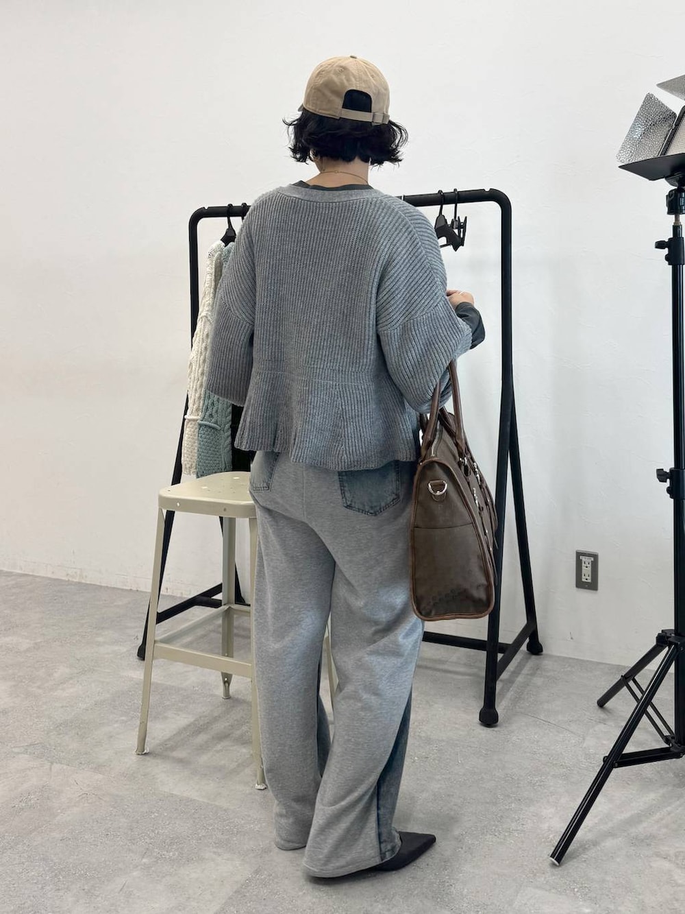 ブルー系のデニムパンツ、グリーン系のトートバッグ、グレー系のTシャツ/カットソーを着用したレディースの秋コーディネートの4枚目の写真