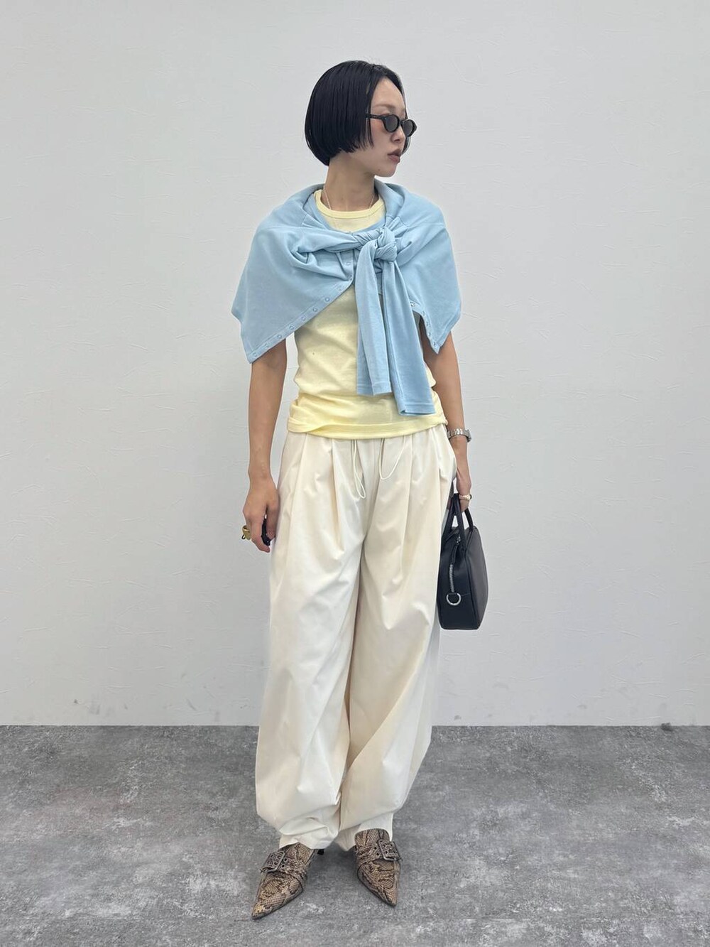 ブラック系のショルダーバッグ、ベージュ系のパンプス、ホワイト系のその他パンツを着用したレディースの冬コーディネートの4枚目の写真