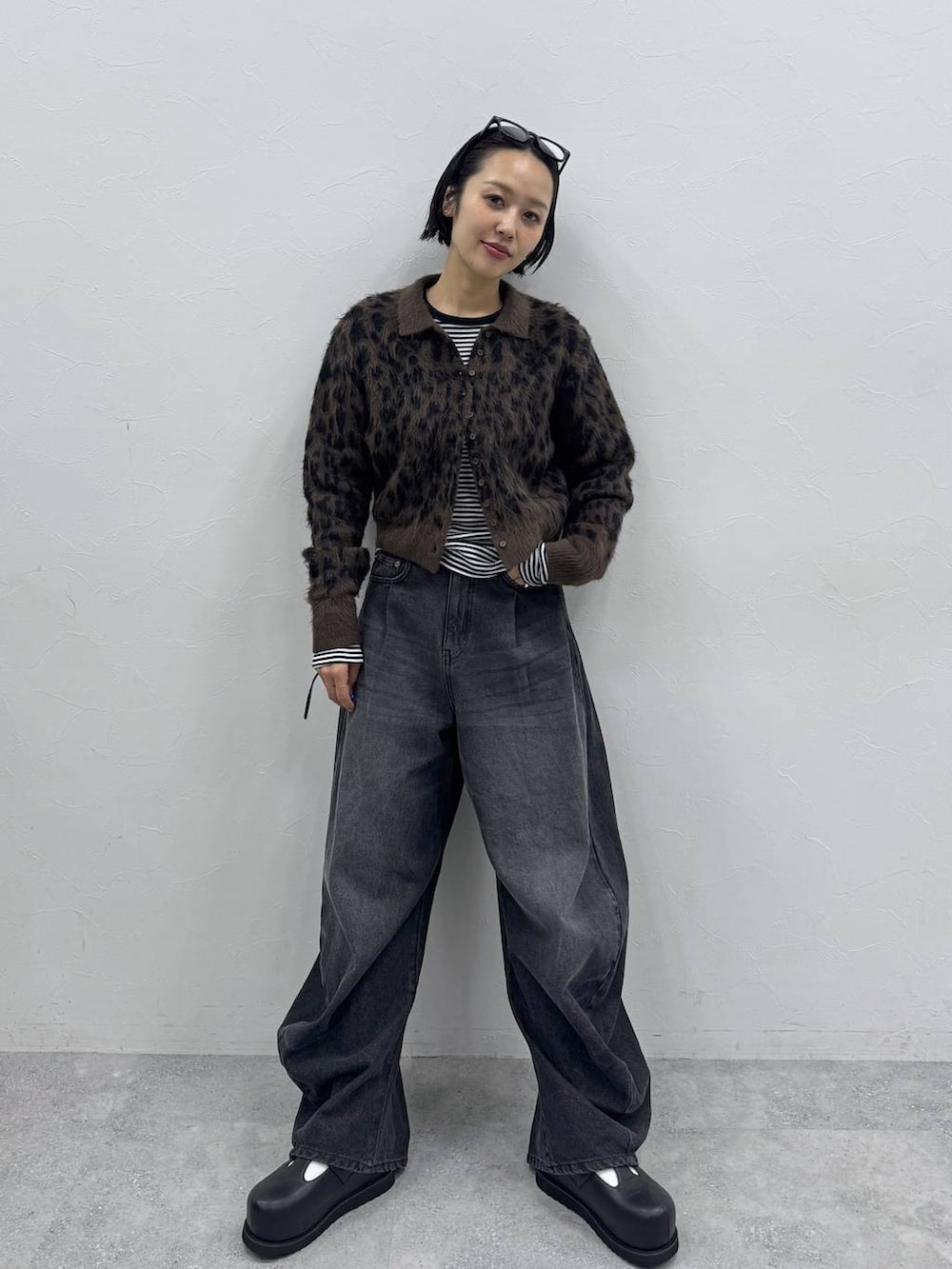 ブラック系のデニムパンツ、ブラウン系のカーディガン/ボレロ、ブラック系のTシャツ/カットソーを着用したレディースの秋コーディネートの4枚目の写真