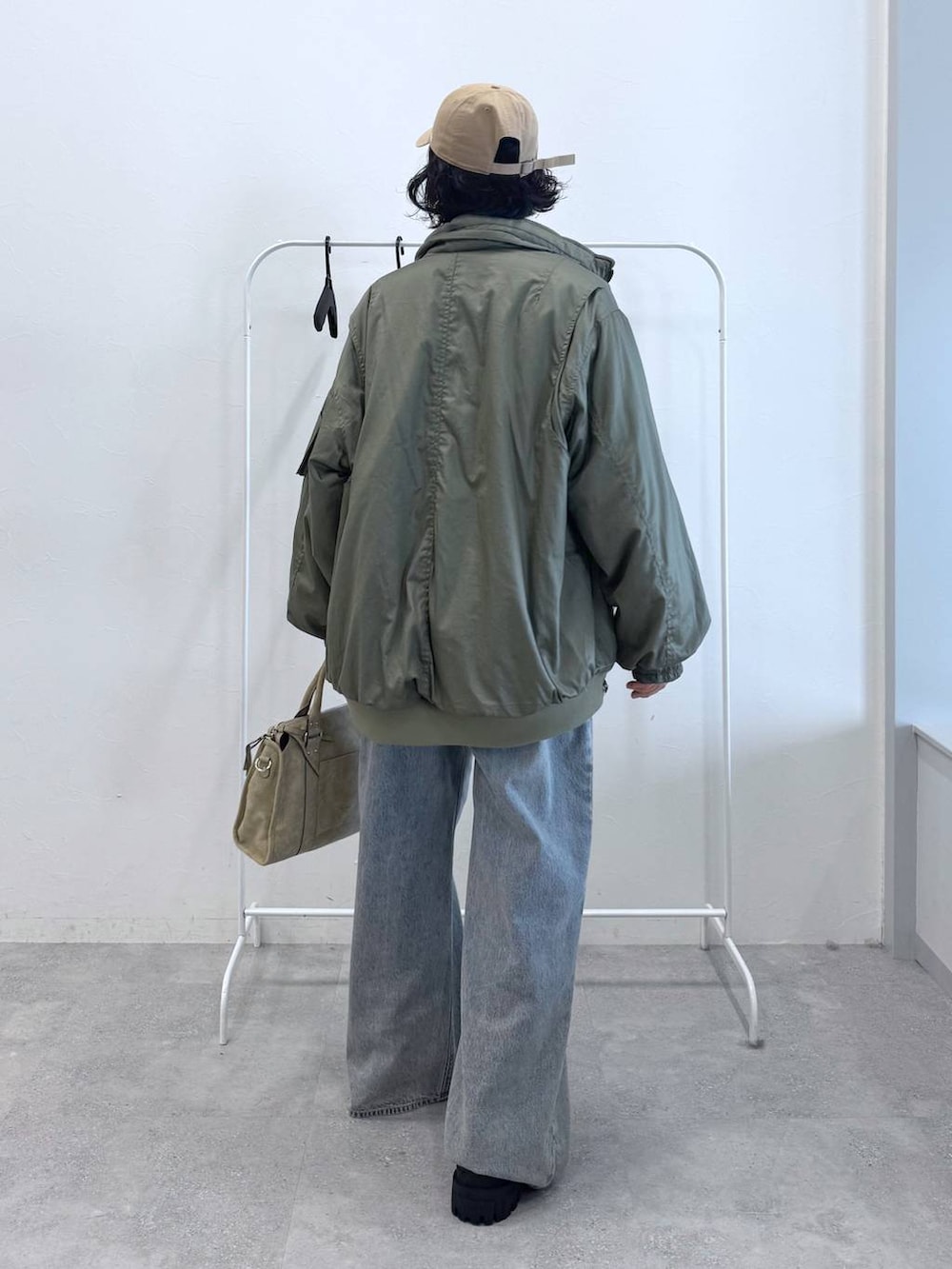 ブルー系のデニムパンツ、ベージュ系のボストンバッグ、ブラック系のブーツを着用したレディースの秋コーディネートの4枚目の写真