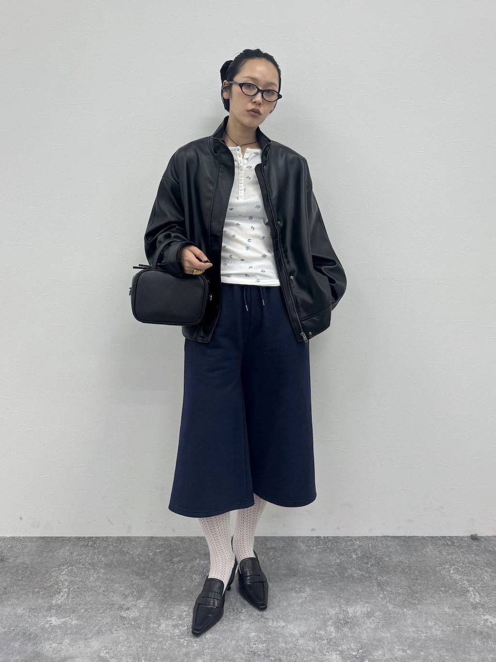 ブラック系のローファー、ブラック系のショルダーバッグ、ブラック系のブルゾンを着用したレディースの冬コーディネートの2枚目の写真