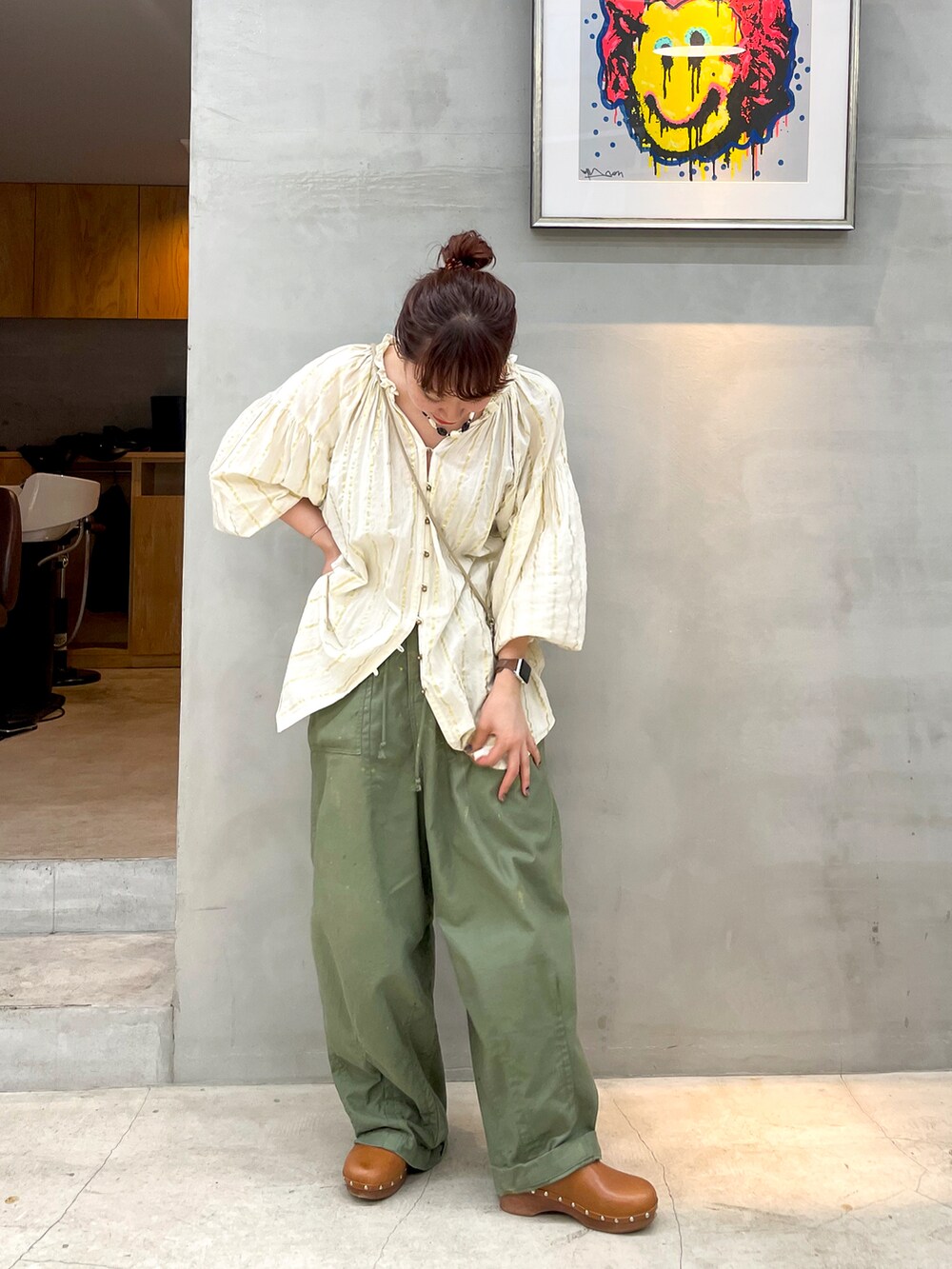 イエロー系のトップス、ブラウン系のシューズ、その他のネックレスを着用したレディースの夏コーディネートの2枚目の写真