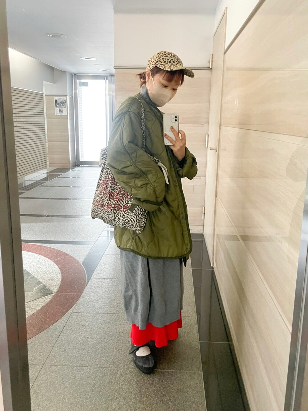 グリーン系のミリタリージャケット、グレー系のワンピース、グレー系のバレエシューズを着用したレディースの冬コーディネートの2枚目の写真