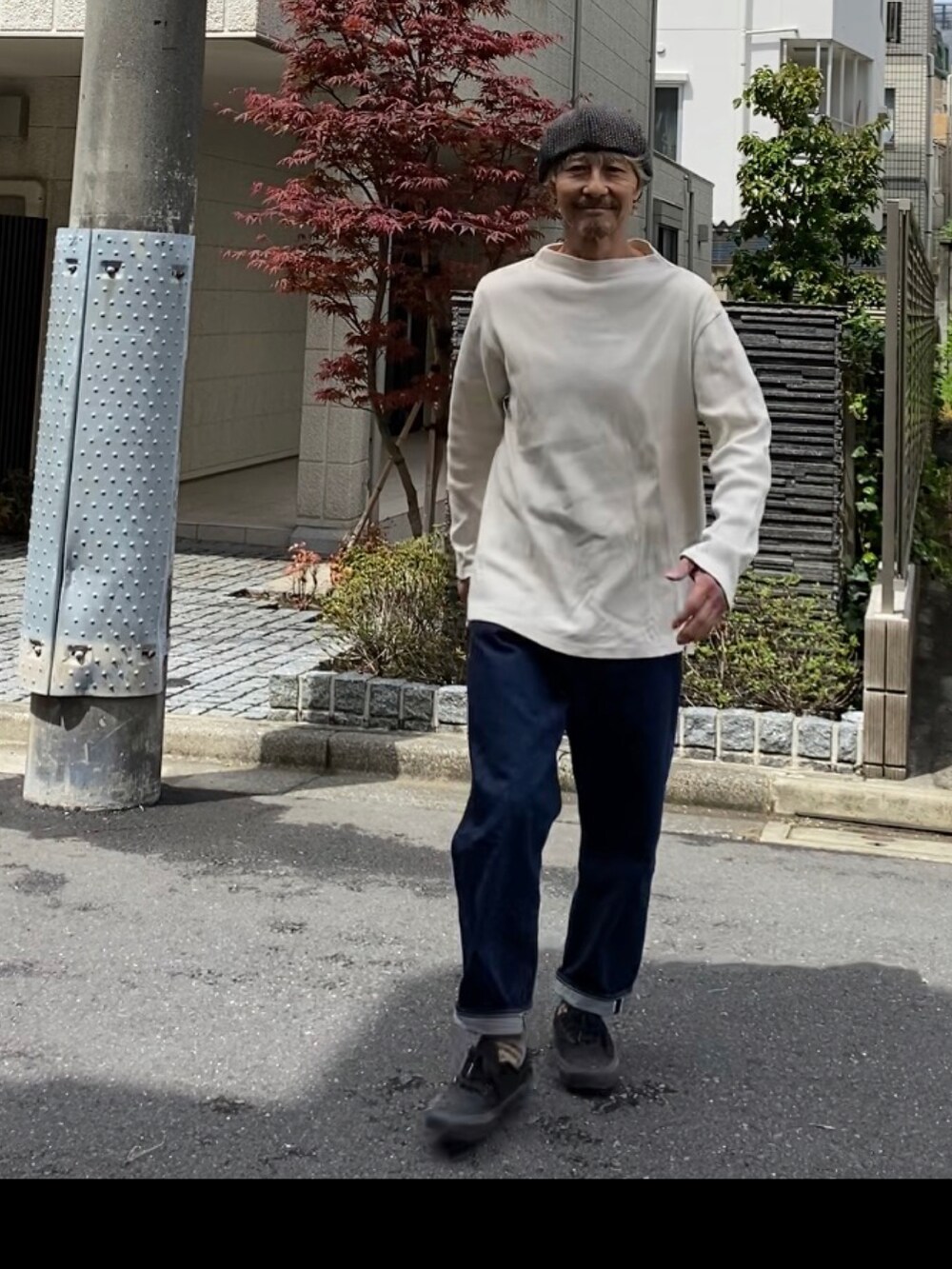 ホワイト系のTシャツ/カットソー、ブルー系のデニムパンツ、ブラック系のスニーカーを着用したメンズの春コーディネートの3枚目の写真