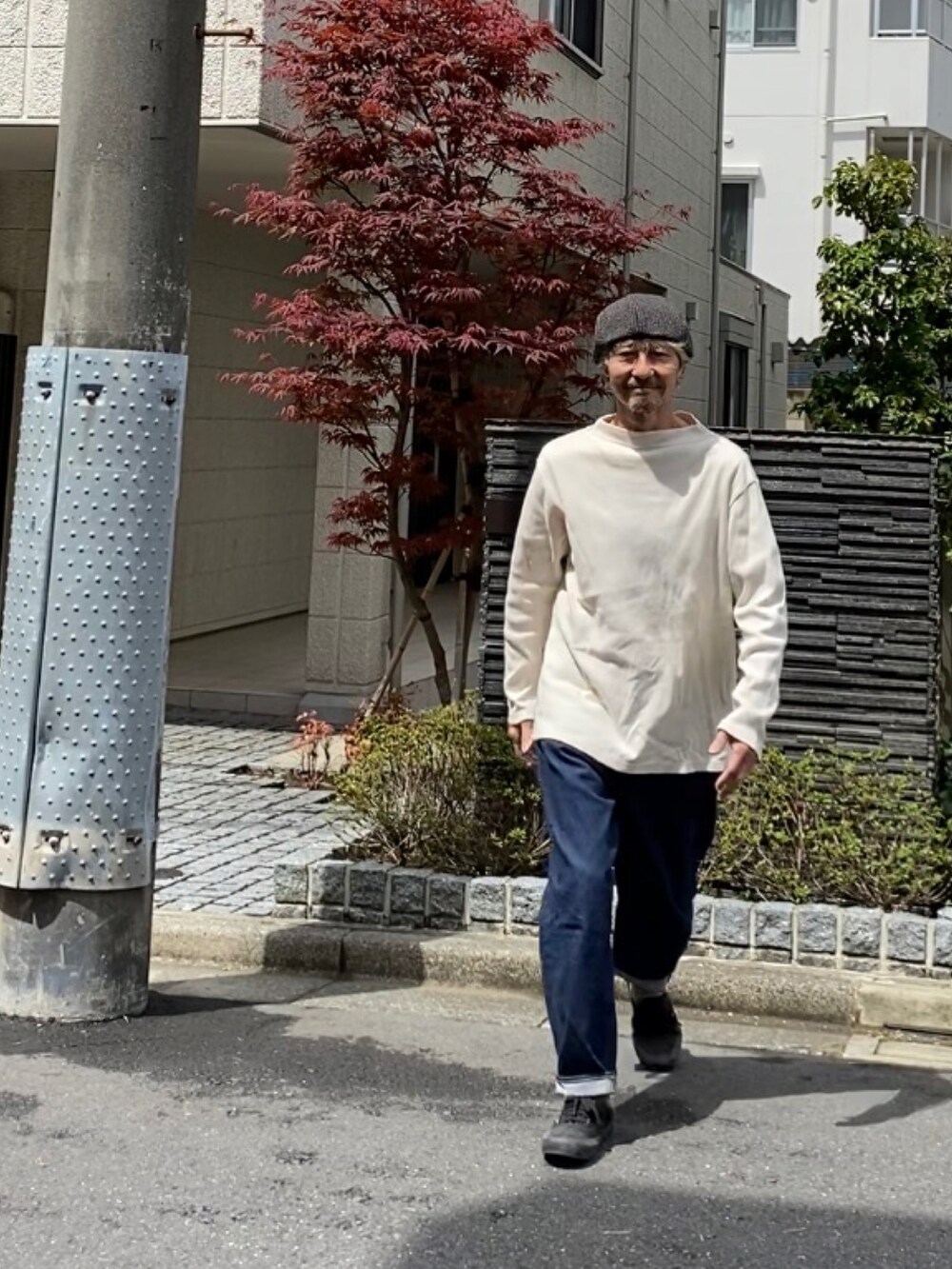 ホワイト系のTシャツ/カットソー、ブルー系のデニムパンツ、ブラック系のスニーカーを着用したメンズの春コーディネートの2枚目の写真