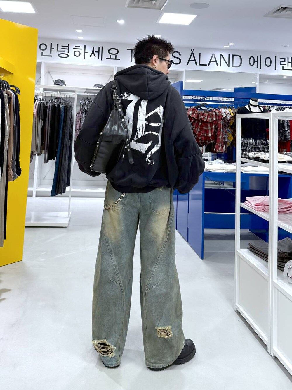 ブルー系のデニムパンツ、ブラック系のショルダーバッグ、ブラック系のTシャツ/カットソーを着用したメンズの夏コーディネートの5枚目の写真