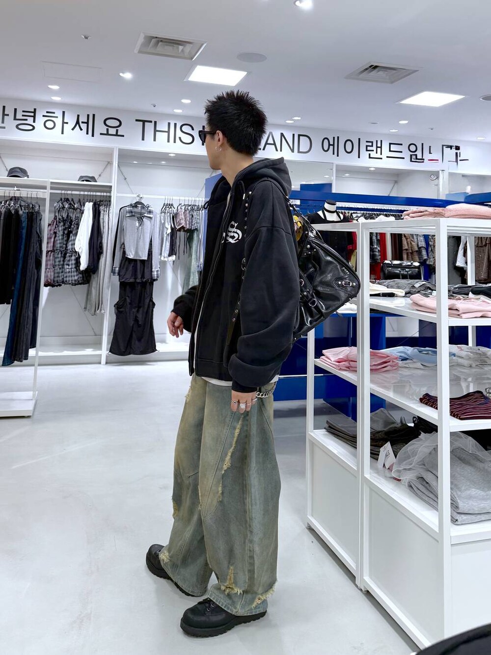 ブルー系のデニムパンツ、ブラック系のショルダーバッグ、ブラック系のTシャツ/カットソーを着用したメンズの夏コーディネートの4枚目の写真