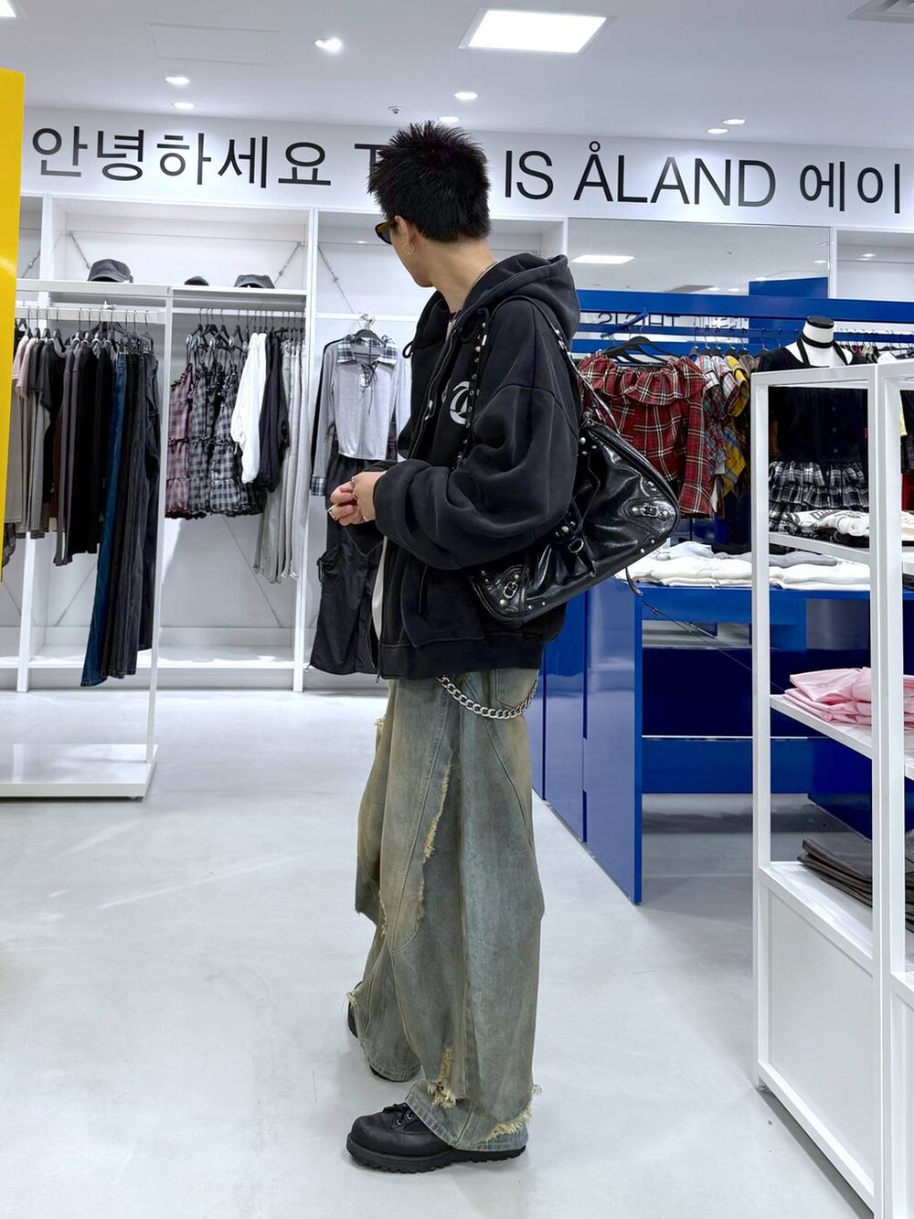 ブルー系のデニムパンツ、ブラック系のショルダーバッグ、ブラック系のTシャツ/カットソーを着用したメンズの夏コーディネートの2枚目の写真