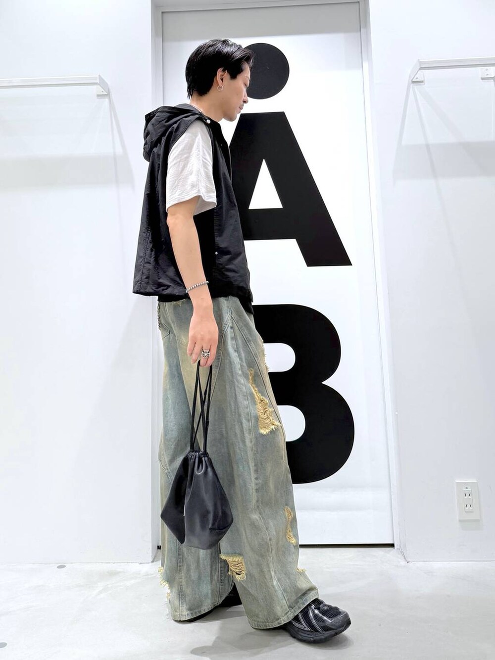ブラック系のショルダーバッグ、ブルー系のデニムパンツ、ブラック系のTシャツ/カットソーを着用したメンズの夏コーディネートの5枚目の写真