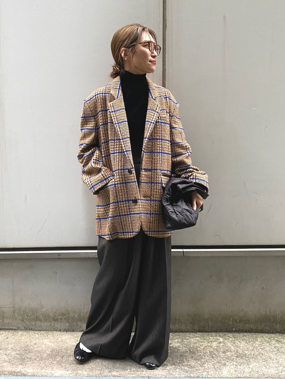 ブラック系のTシャツ/カットソー、ベージュ系のテーラードジャケット、ブラック系のトートバッグを着用したレディースの秋コーディネートの2枚目の写真