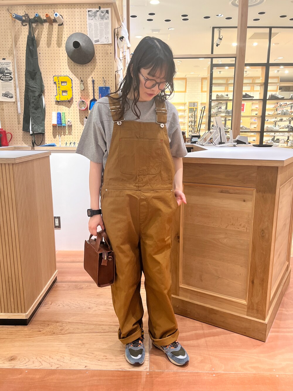 ブラウン系のサロペット/オーバーオール、ホワイト系のシャツ/ブラウス、グレー系のTシャツ/カットソーを着用したレディースの春コーディネートの3枚目の写真